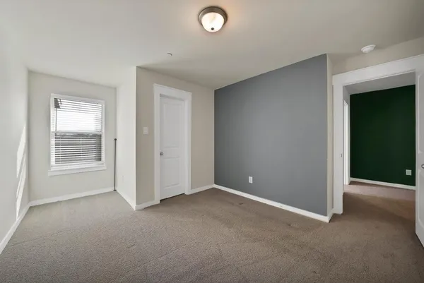 an empty room with windows and closet