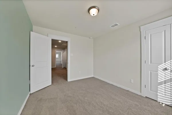 an empty room with closet and a window