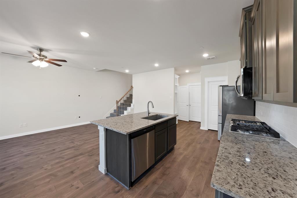 6610 Baritone Court Sachse, TX 75048 - Photo 4 of 30 a kitchen with a stove a refrigerator and a sink