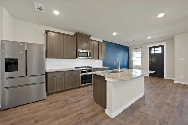 a kitchen with stainless steel appliances and white cabinets