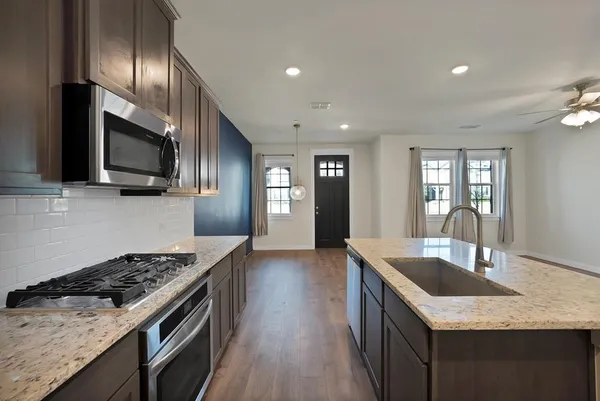 a kitchen with granite countertop stainless steel appliances and wooden cabinets