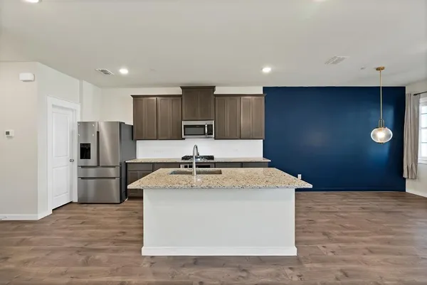 a kitchen with a stove a refrigerator and a sink
