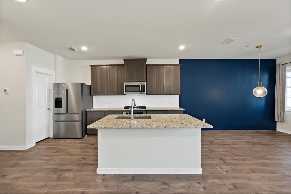 6610 Baritone Court Sachse, TX 75048 - Photo 10 of 30 a kitchen with a stove a refrigerator and a sink