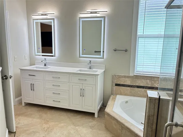a bathroom with a tub sink and mirror