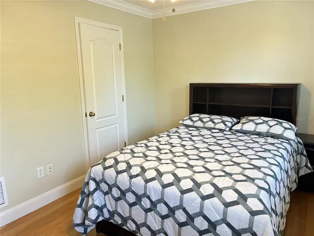 a large bed sitting in a bedroom next to a window and wooden floor