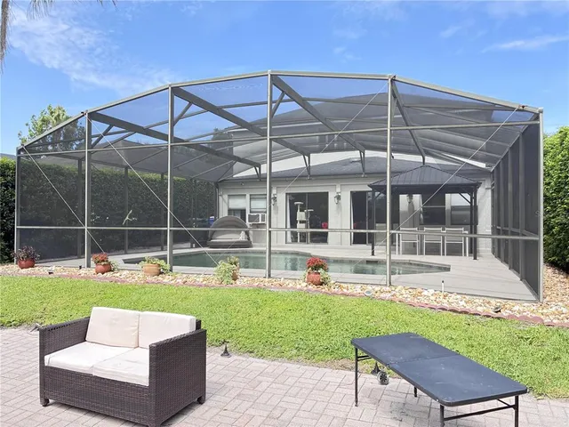 a view of a backyard with a patio and swimming pool