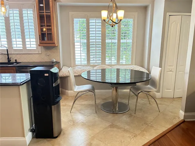 a dining room with chandelier and wooden floor