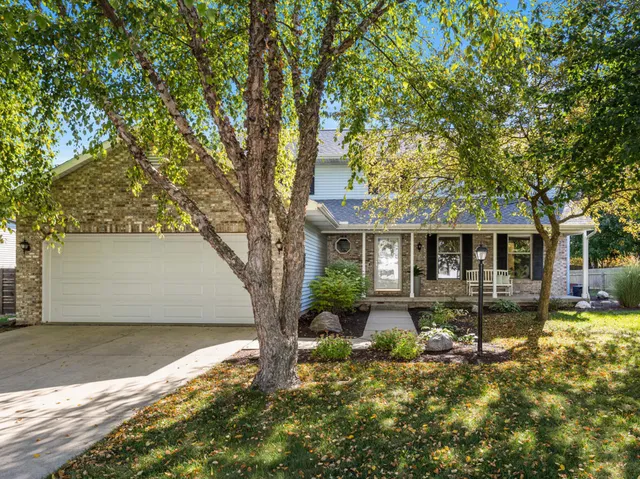 a front view of house with yard space and trees in the background