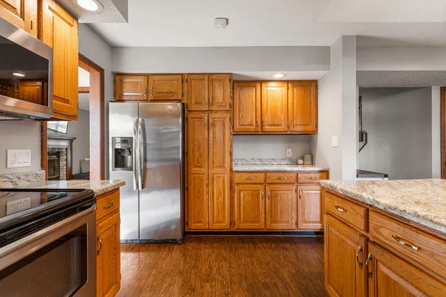 a kitchen with stainless steel appliances granite countertop a refrigerator and a stove top oven