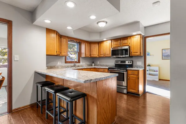 a kitchen with granite countertop a stove top oven a sink a dining table and chairs