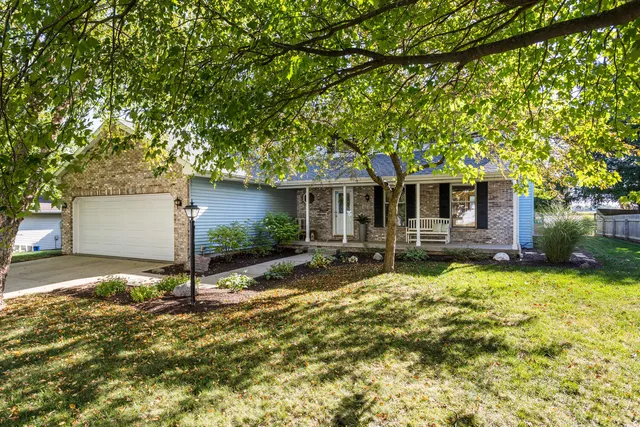 a front view of house with yard and trees in the background