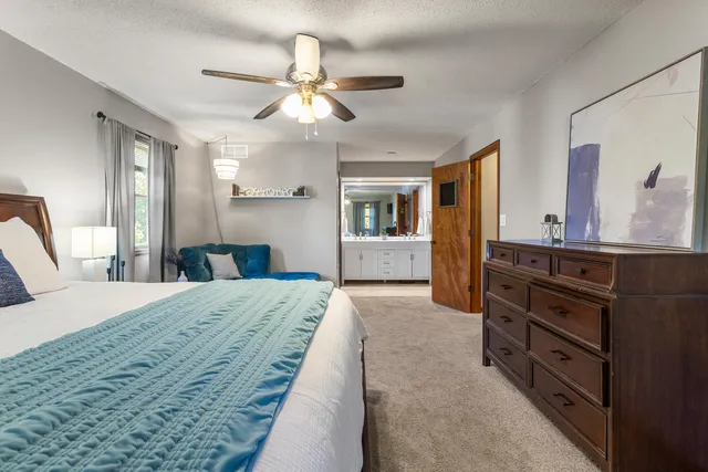 a spacious bedroom with a large bed and dresser