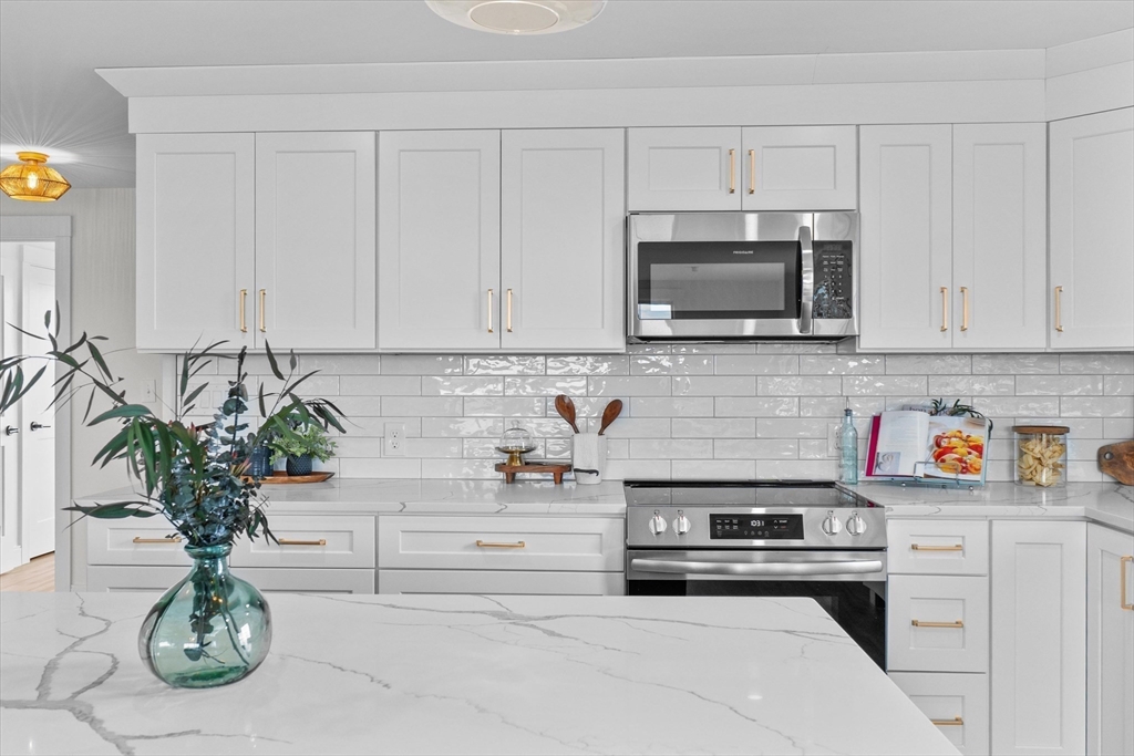 30 Cable Avenue, Unit 3 Salisbury, MA 01952 - Photo 11 of 31 a kitchen with stainless steel appliances granite countertop white cabinets a stove top oven a sink and dishwasher