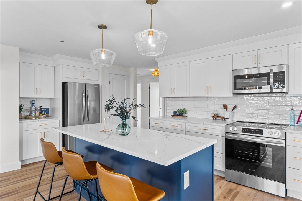 30 Cable Avenue, Unit 3 Salisbury, MA 01952 - Photo 8 of 31 a kitchen with stainless steel appliances a stove a sink a microwave a refrigerator and cabinets