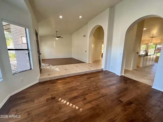 a view of empty room with wooden floor and window