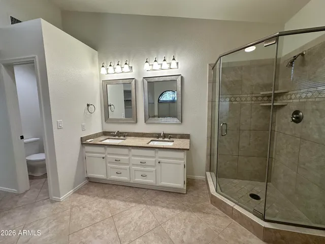 a bathroom with a granite countertop sink a mirror and a shower