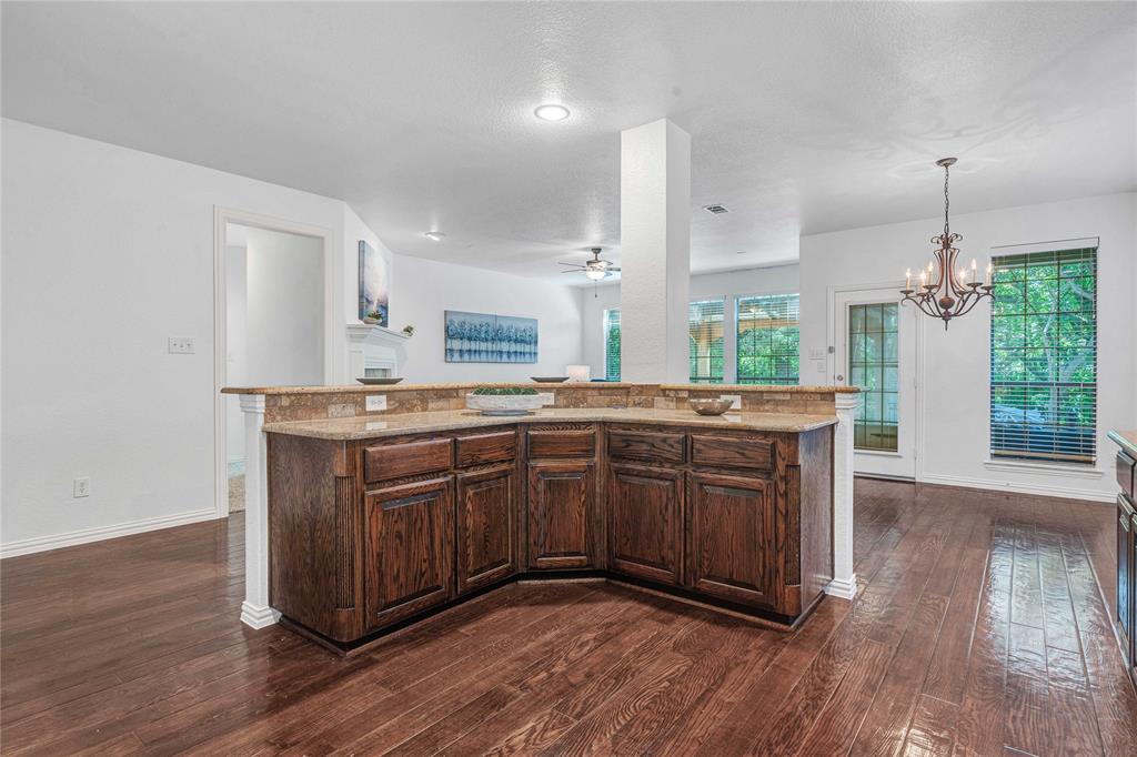 1504 Tangle Ridge Drive McKinney, TX 75071 - Photo 14 of 36 a kitchen with stainless steel appliances granite countertop a sink a stove a refrigerator and wooden floor