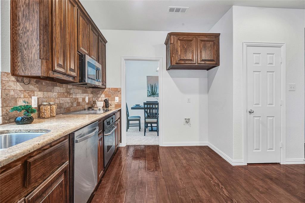 1504 Tangle Ridge Drive McKinney, TX 75071 - Photo 16 of 36 a kitchen with cabinets and wooden floor