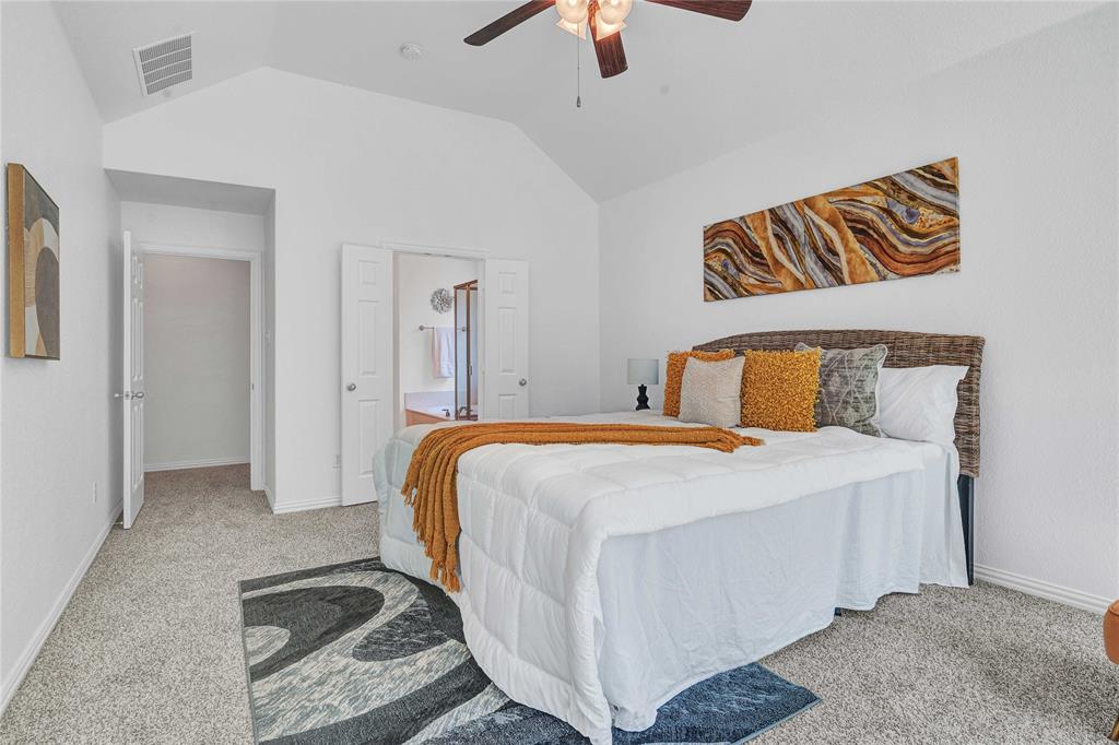 1504 Tangle Ridge Drive McKinney, TX 75071 - Photo 18 of 36 a bedroom with a bed and a chandelier