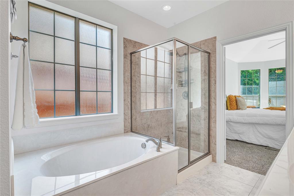 1504 Tangle Ridge Drive McKinney, TX 75071 - Photo 20 of 36 a bathroom with a tub a window and a shower