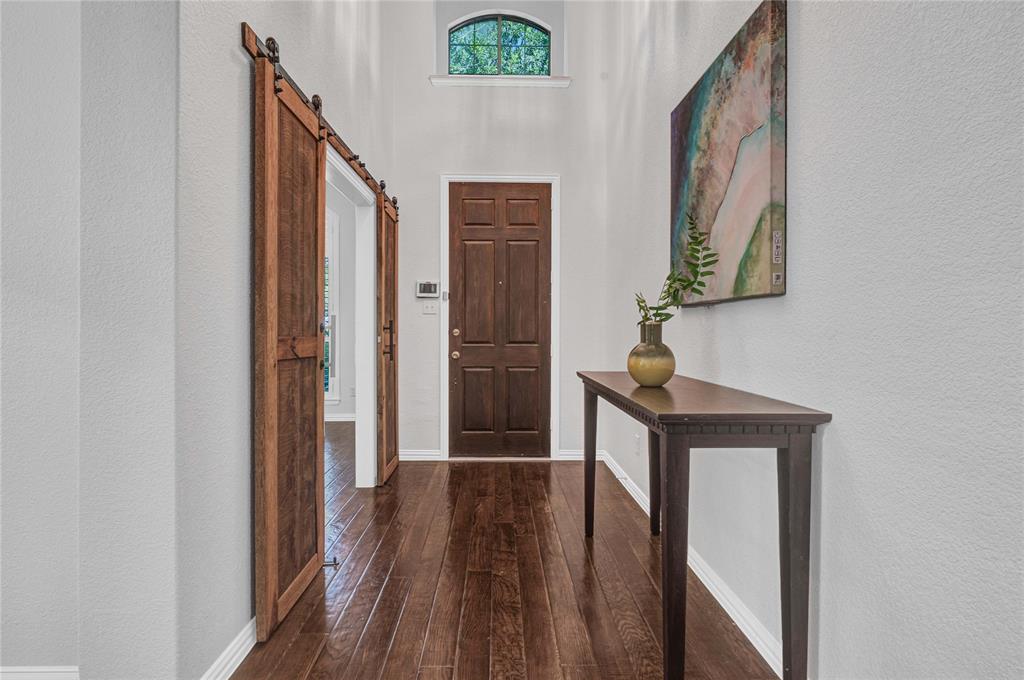 1504 Tangle Ridge Drive McKinney, TX 75071 - Photo 3 of 36 a view of a hallway with wooden floor and staircase