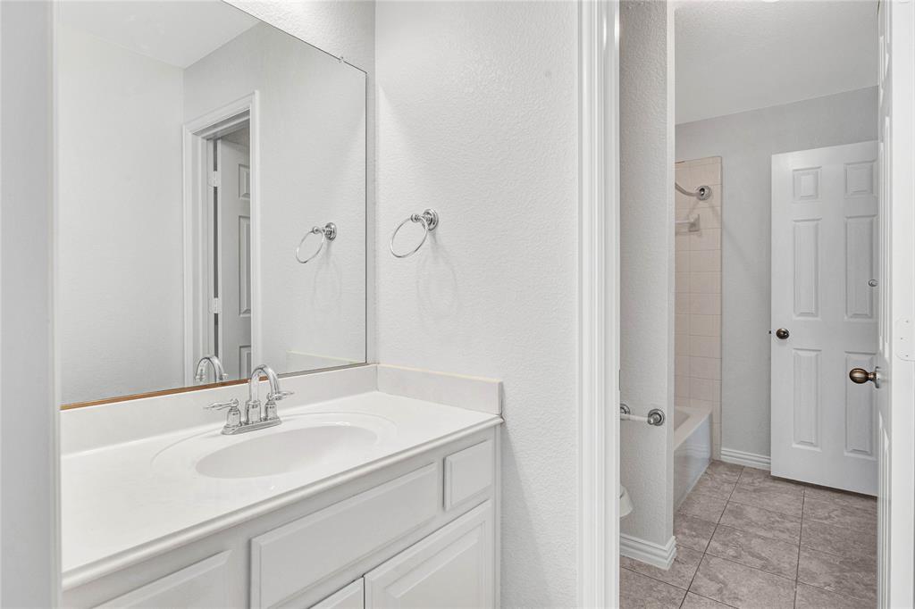 1504 Tangle Ridge Drive McKinney, TX 75071 - Photo 31 of 36 a bathroom with a sink and a mirror