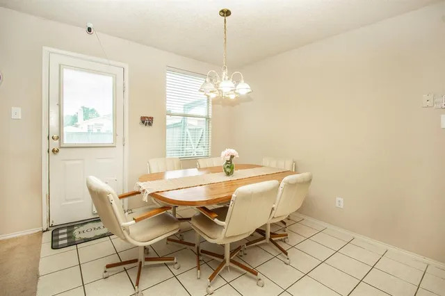a dining room with chandelier and wooden floor