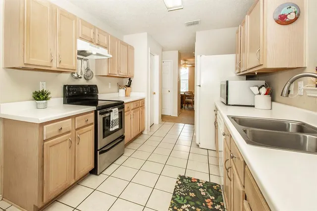 a kitchen with a sink stove top oven and cabinets