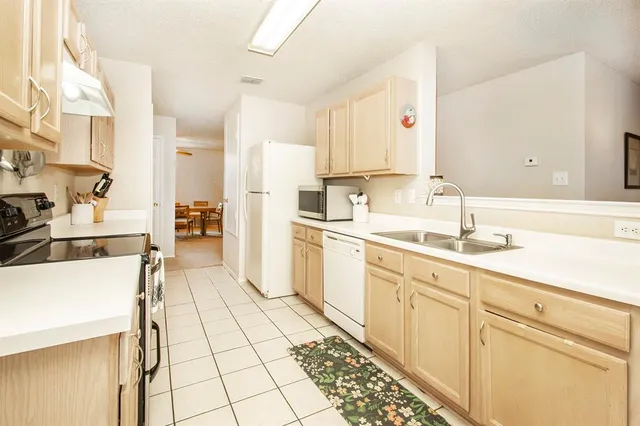 a large white kitchen with cabinets