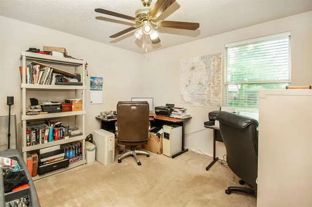 a view of a workspace with furniture and a window