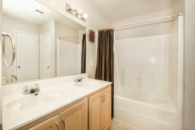 a bathroom with a bathtub shower sink vanity and a mirror