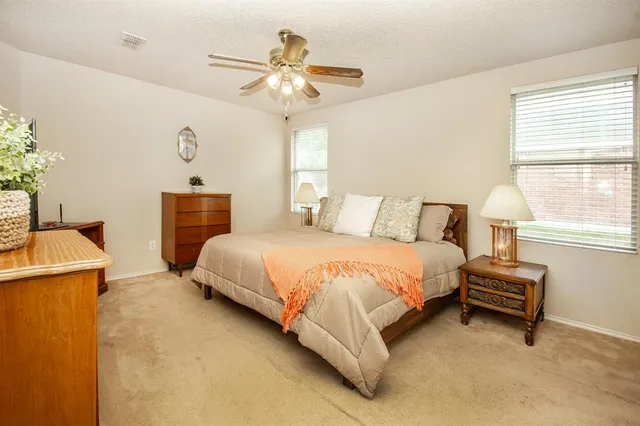 a spacious bedroom with a bed and a chandelier