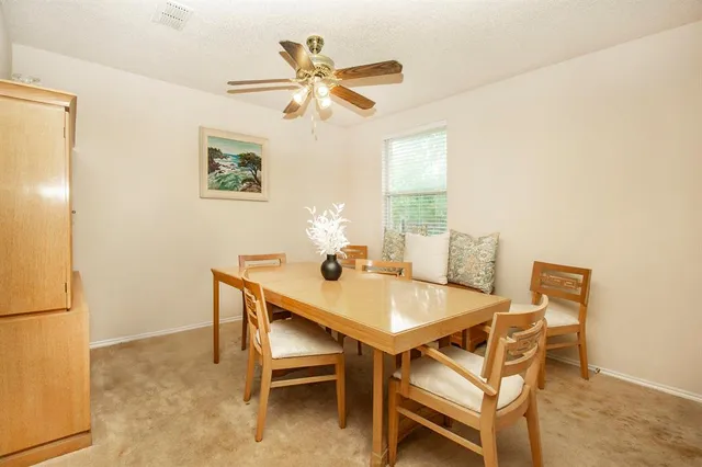 a view of a dining room with furniture and a chandelier fan