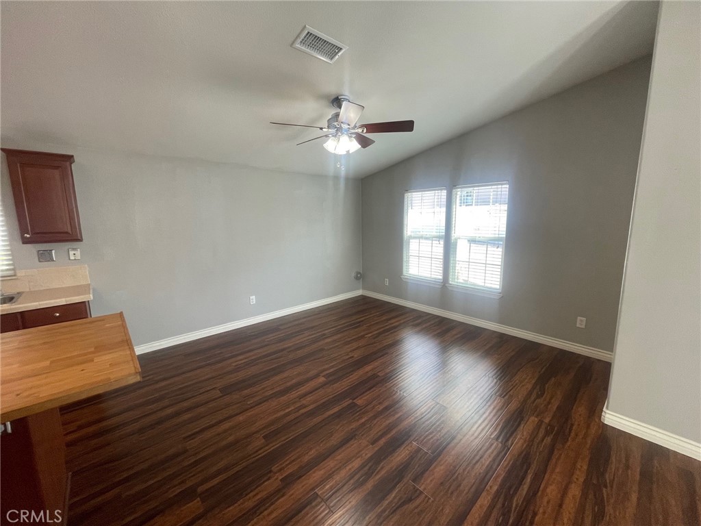 15181 Van Buren Boulevard, Unit 22 Riverside, CA 92504 - Photo 11 of 61 a view of an empty room with wooden floor and a window