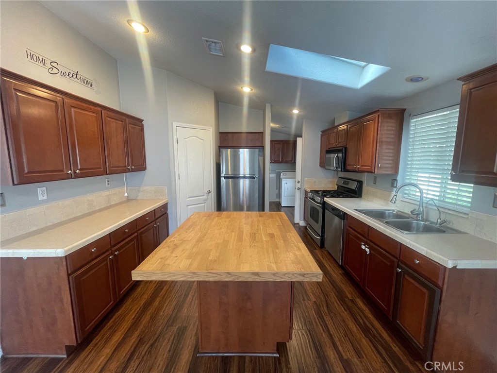 15181 Van Buren Boulevard, Unit 22 Riverside, CA 92504 - Photo 16 of 61 a kitchen with stainless steel appliances wooden cabinets a stove a sink and a refrigerator