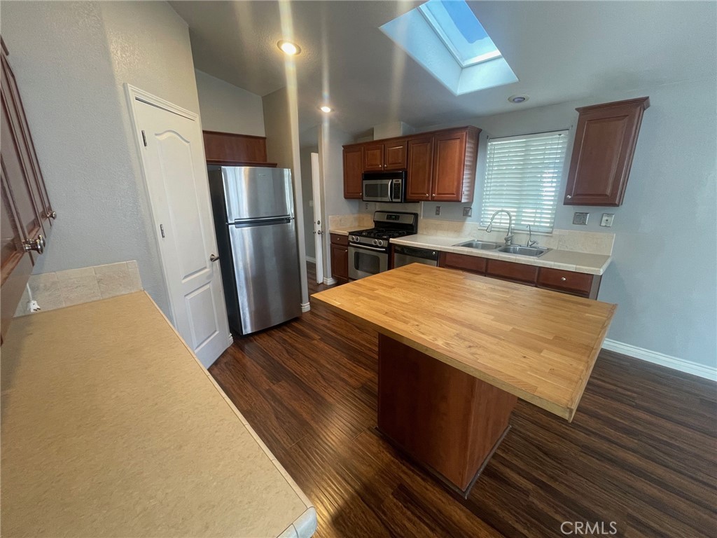 15181 Van Buren Boulevard, Unit 22 Riverside, CA 92504 - Photo 17 of 61 a kitchen with sink a refrigerator and microwave