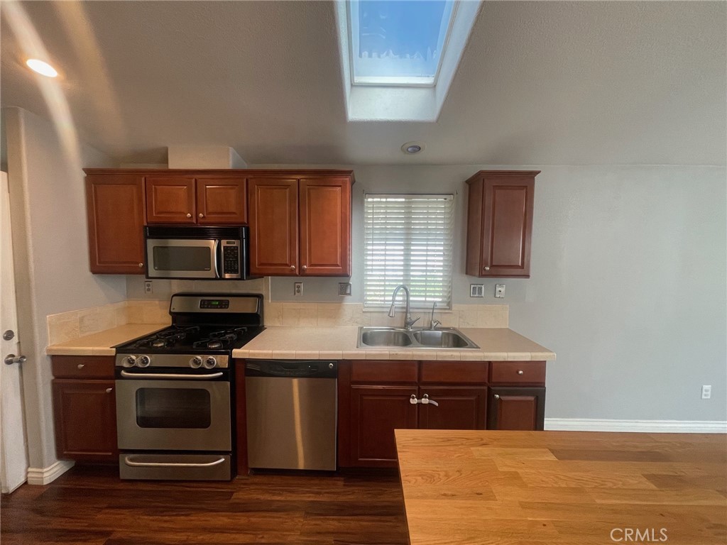 15181 Van Buren Boulevard, Unit 22 Riverside, CA 92504 - Photo 20 of 61 a kitchen with granite countertop a sink cabinets and stainless steel appliances