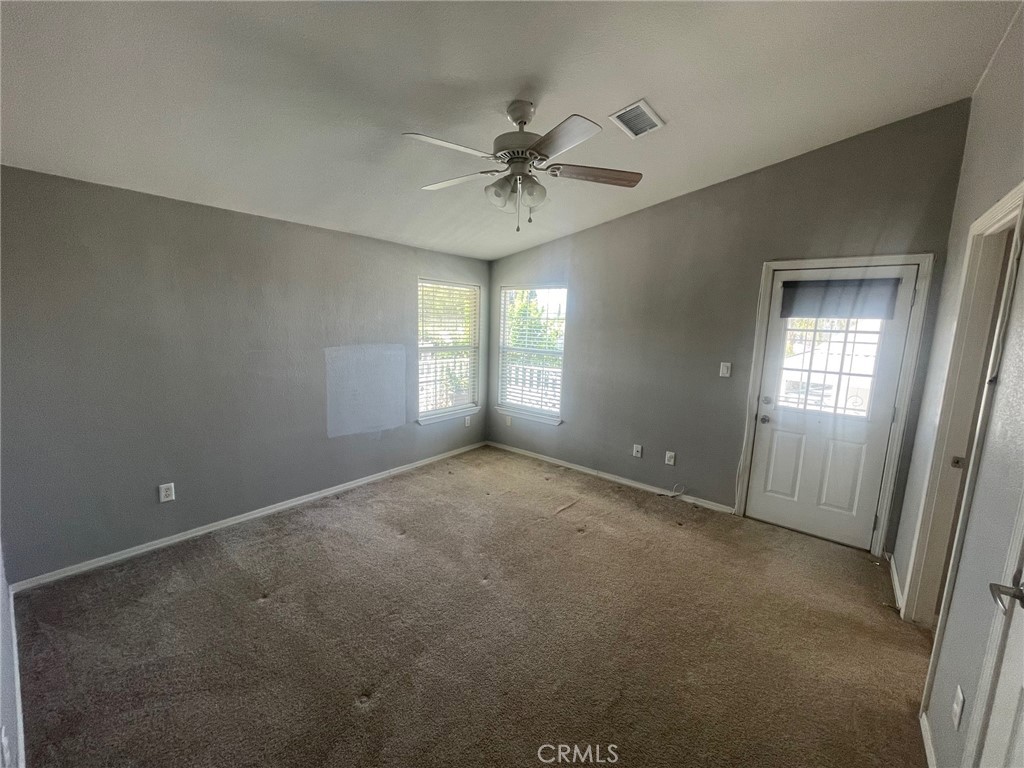 15181 Van Buren Boulevard, Unit 22 Riverside, CA 92504 - Photo 32 of 61 an empty room with windows and fan