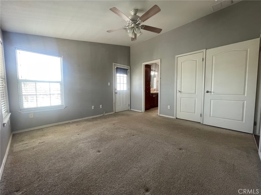 15181 Van Buren Boulevard, Unit 22 Riverside, CA 92504 - Photo 33 of 61 an empty room with chandelier fan and windows