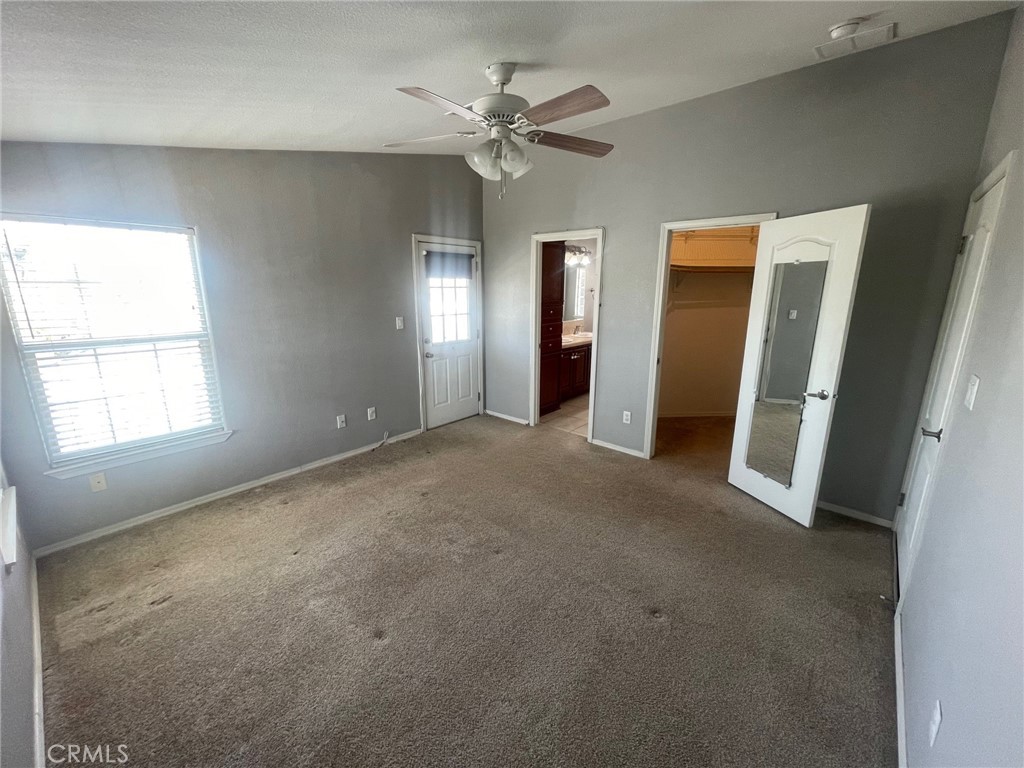 15181 Van Buren Boulevard, Unit 22 Riverside, CA 92504 - Photo 34 of 61 an empty room with chandelier fan and windows