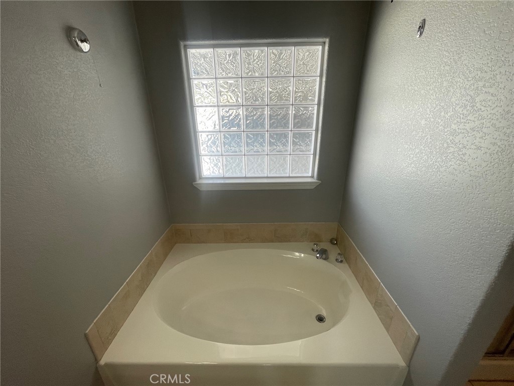 15181 Van Buren Boulevard, Unit 22 Riverside, CA 92504 - Photo 41 of 61 a white bath tub sitting in a bathroom