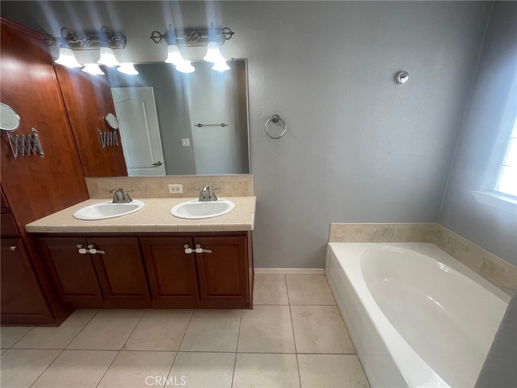 15181 Van Buren Boulevard, Unit 22 Riverside, CA 92504 - Photo 42 of 61 a bathroom with a sink a vanity and a bathtub
