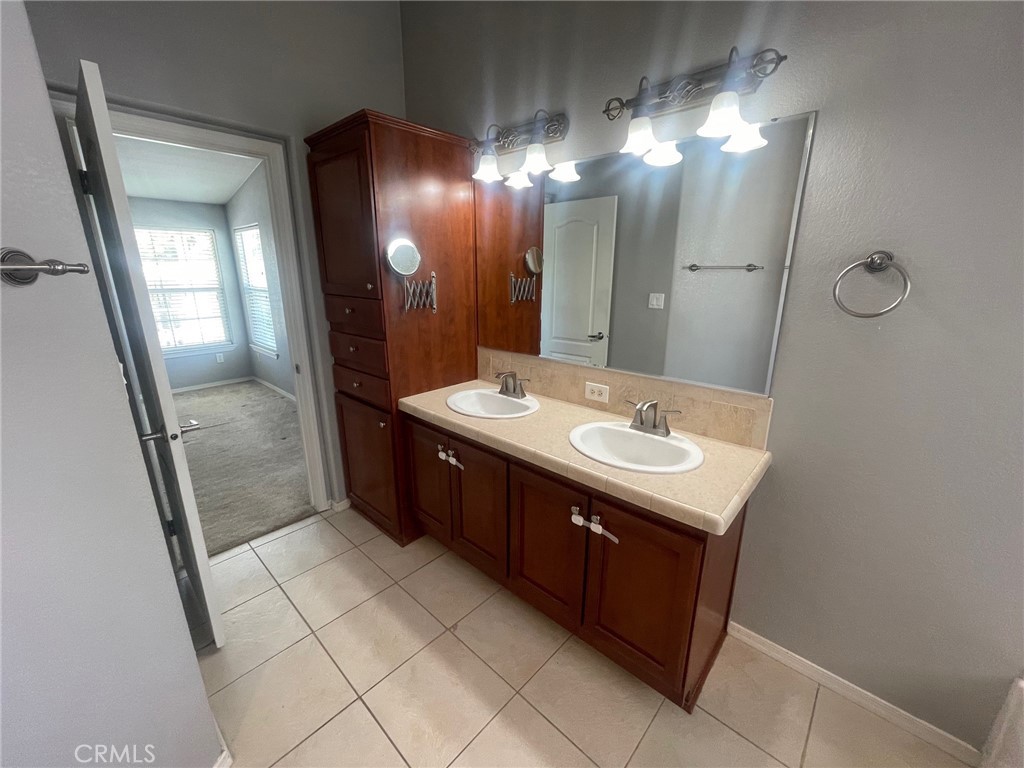 15181 Van Buren Boulevard, Unit 22 Riverside, CA 92504 - Photo 43 of 61 a bathroom with a sink a mirror and a shower