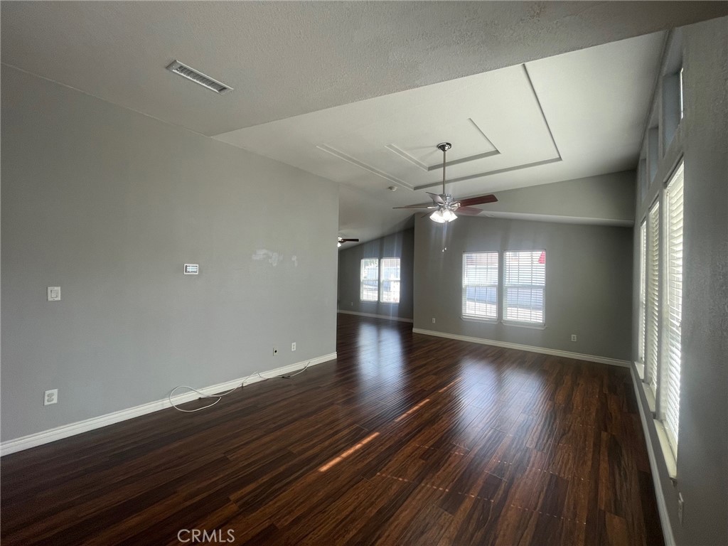 15181 Van Buren Boulevard, Unit 22 Riverside, CA 92504 - Photo 5 of 61 a view of an empty room with wooden floor and a window