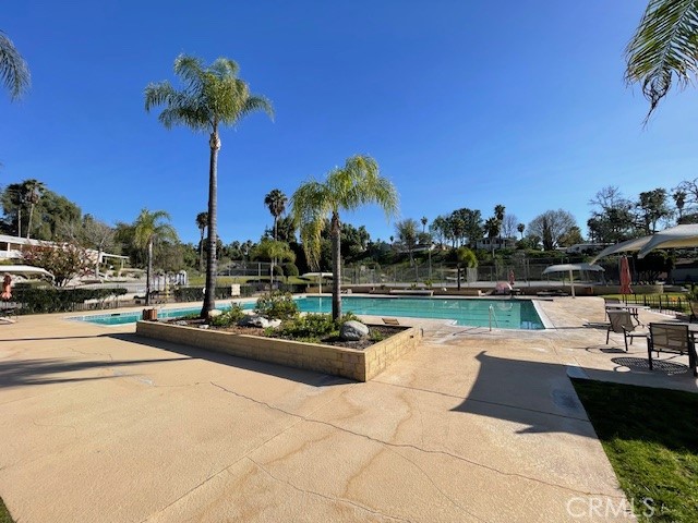 15181 Van Buren Boulevard, Unit 22 Riverside, CA 92504 - Photo 57 of 61 a view of a swimming pool with a table and chairs
