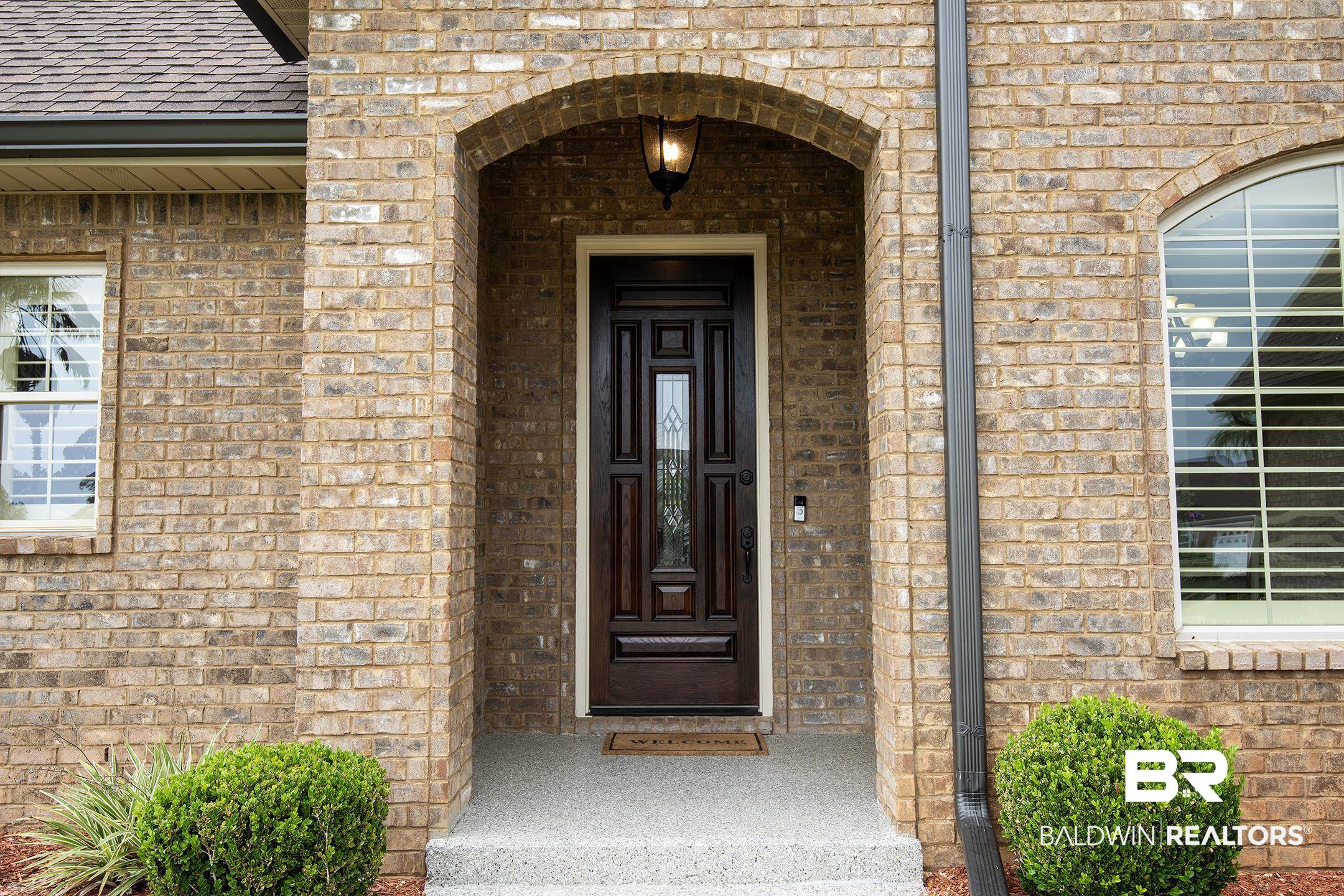 9357 Lakeview Drive Foley, AL 36535 - Photo 11 of 68 Arched entryway with a dark wood-finish front door and glass inserts