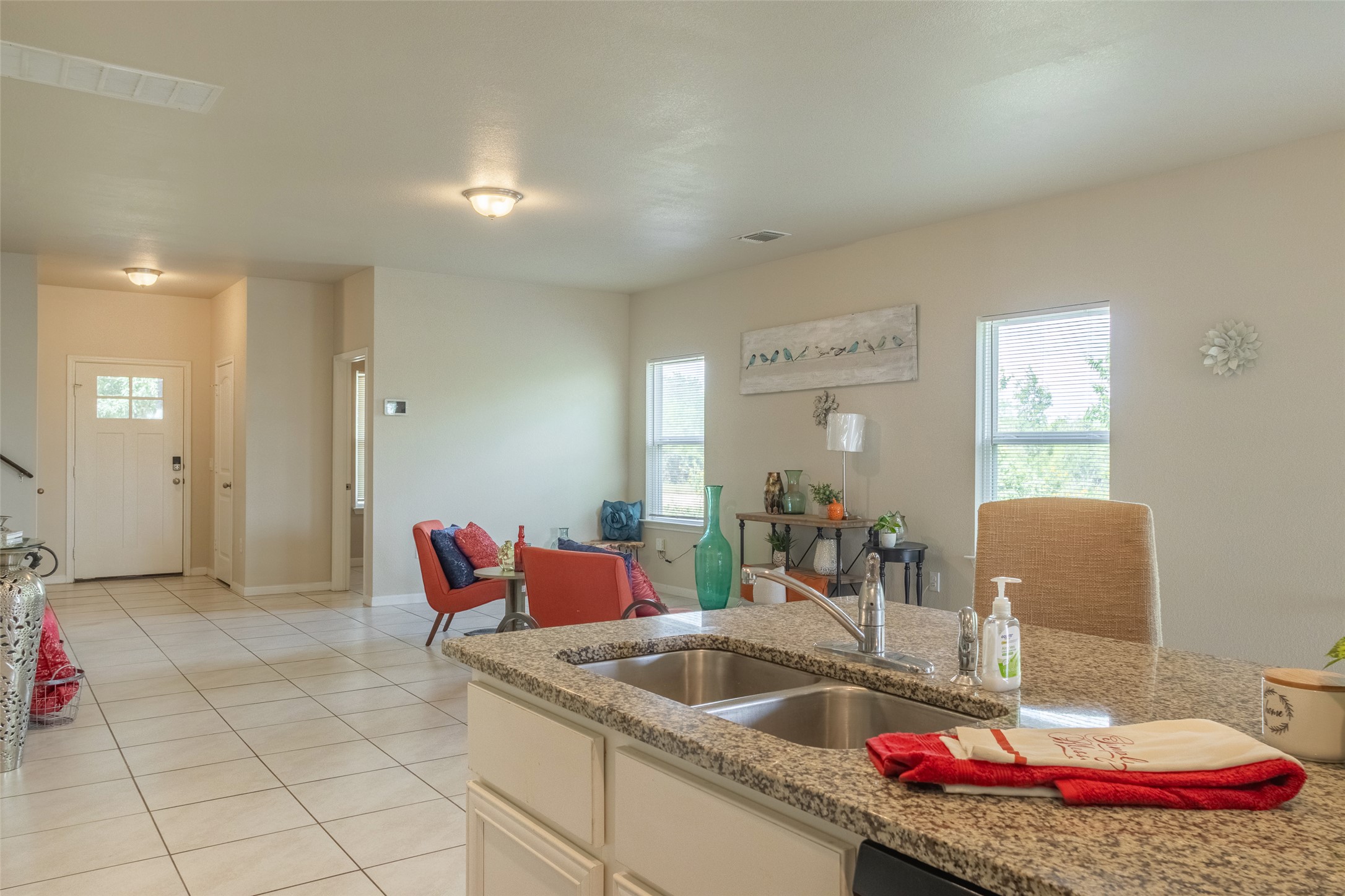 7225 Ranchito Drive Austin, TX 78744 - Photo 8 of 40 A well-lit interior showcases an inviting open-plan layout with a functional kitchen island and ample space for relaxation.