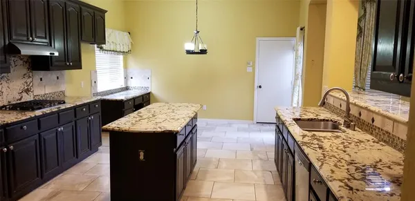 a kitchen with sink stove and cabinets