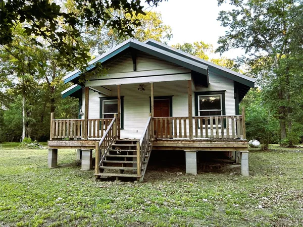 a view of a house with a deck and a yard