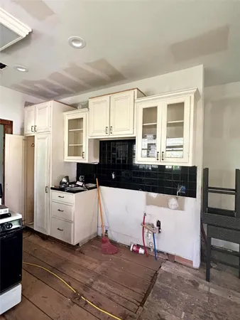 a kitchen with granite countertop a refrigerator and a stove top oven